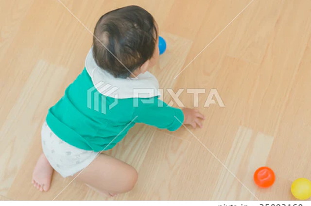床暖房の保育室でボール遊びをする赤ちゃん